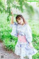 A woman in a blue and pink kimono posing for a picture.