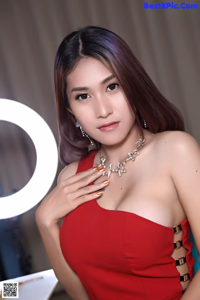 A woman in a red dress posing for a picture.