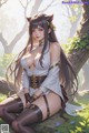 A woman sitting on a tree branch in a forest.