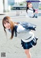 A young woman in a school uniform is posing for a picture.