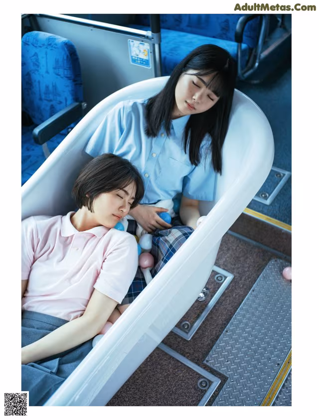A woman and a boy sleeping in a bathtub on a train.