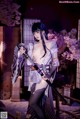 A woman in a kimono holding a samurai sword.