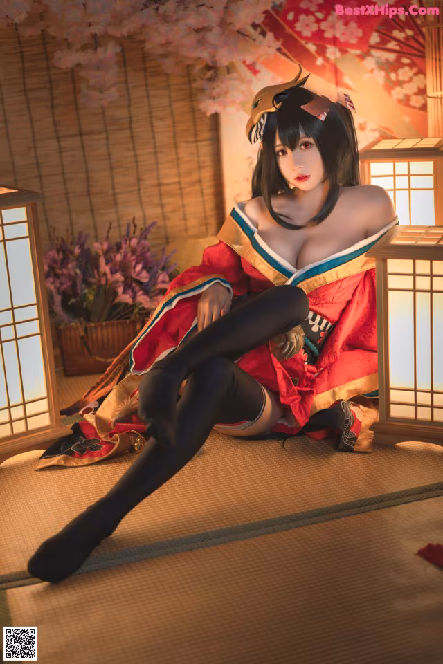 A woman in a kimono sitting on the floor next to a lamp.