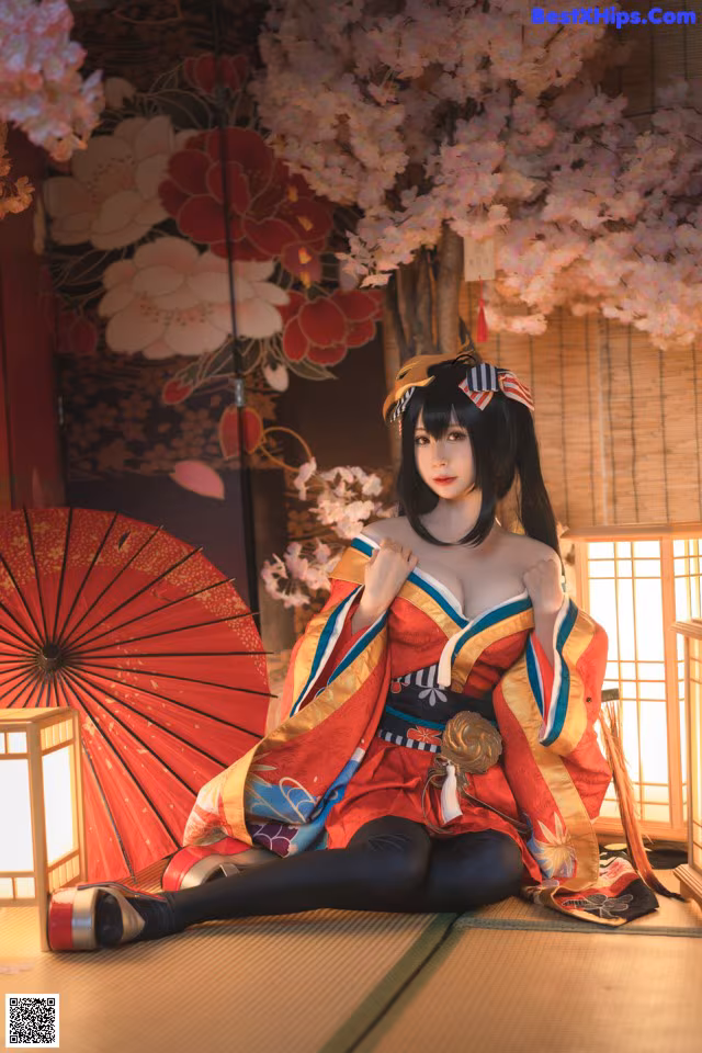 A woman in a kimono sitting on the floor with an umbrella.