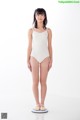 A woman in a white leotard standing on a scale.