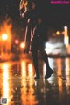 A woman in a black coat is walking in the rain.